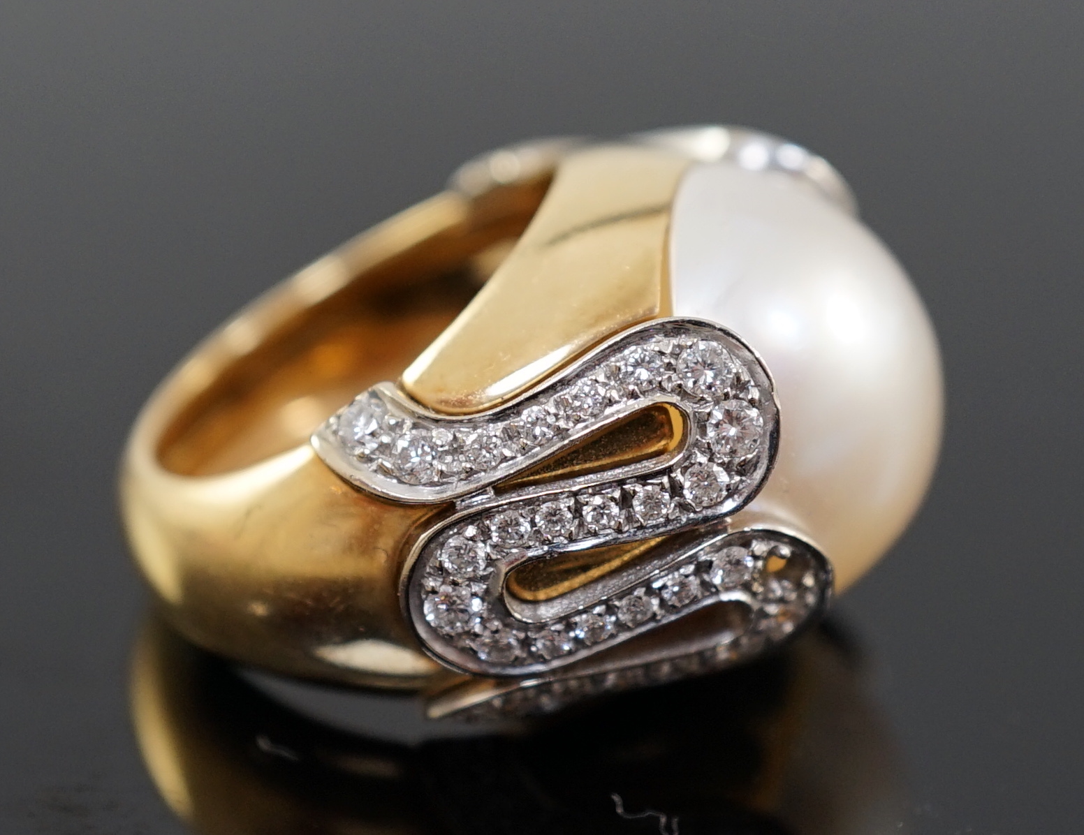 A modern Italian Versace 18ct gold and half cultured pearl set dress ring, with round brilliant cut diamond set shoulders